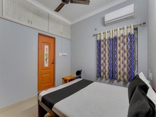 a bedroom with a bed and a window at OYO Blue jay in Chennai