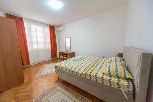 a bedroom with a bed in the corner of a room at center_apartment_LUX in Podgorica