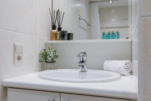 a white bathroom with a sink and a mirror at Cosy apartment with frontal seaview in Nieuwpoort