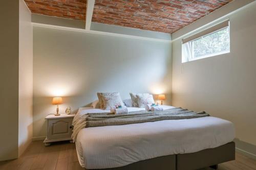 Un dormitorio con una cama grande y una ventana en Charming house "De Ransuil" in De Haan, en De Haan