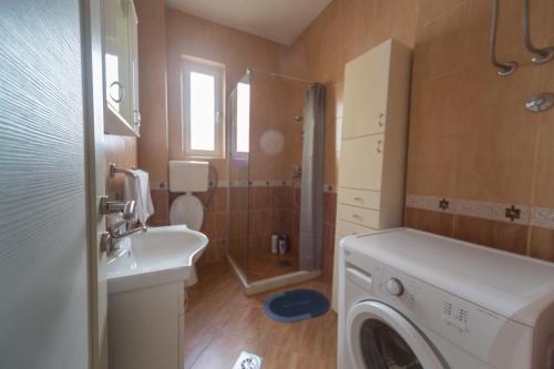 a bathroom with a sink and a washing machine at center_apartment_LUX in Podgorica