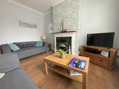 a living room with a couch and a fireplace at Downs Gate Cottage in Eastbourne