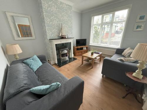 a living room with a couch and a fireplace at Downs Gate Cottage in Eastbourne