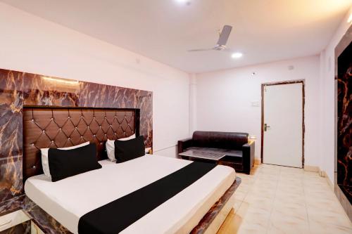 a bedroom with a large bed and a chair at OYO Payal Guest House in Brahmapur