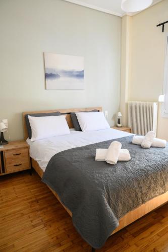 a bedroom with a large bed with two towels on it at Stella’s Minimal Lodge in Tríkala