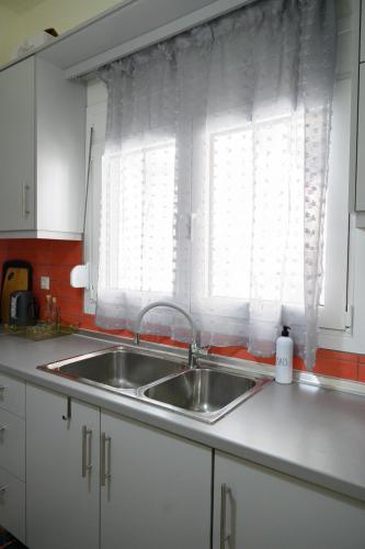 a kitchen counter with a sink and a window at Stella’s Minimal Lodge in Tríkala