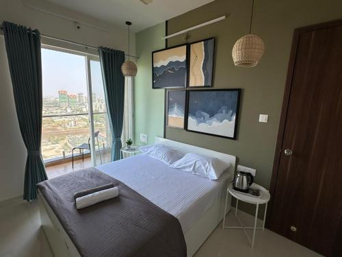 um quarto com uma cama e uma grande janela em Sky: Soothing Oasis near Balewadi High Street em Pune