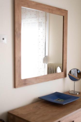 a mirror on a wall above a wooden table at Stella’s Minimal Lodge in Tríkala
