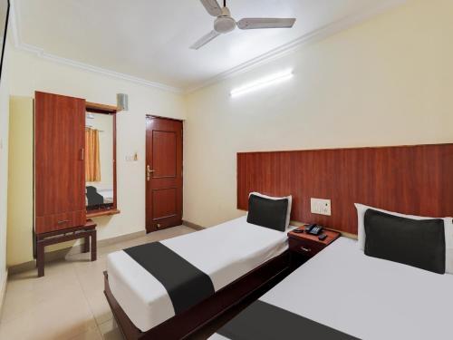 a hotel room with two beds and a mirror at OYO Meenaachi Inn in Chennai