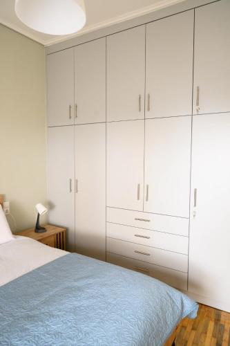 a bedroom with white cabinets and a bed at Stella’s Minimal Lodge in Tríkala