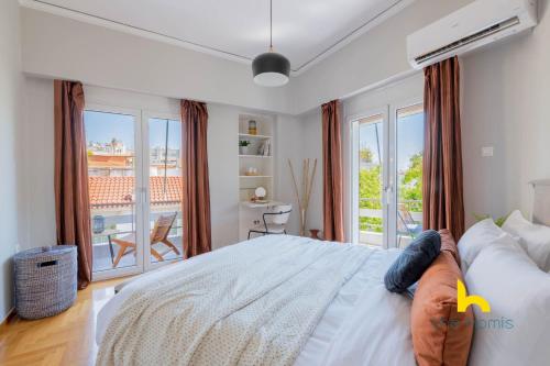 ein Schlafzimmer mit einem großen Bett und einem Balkon in der Unterkunft Sun-splashed sanctum with big balconies, Acropolis in Athen