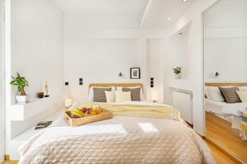 a bedroom with a bed with a basket of fruit on it at OPEN SKIES- PENTHOUSE IN PLAKA- ACROPOLIS VIEW! in Athens