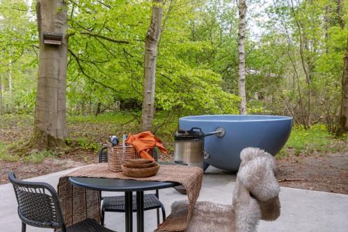 a table with a bath tub and a table with at Huswell - Cozy Forest Cabinet with Private Hot Tub in Stekene