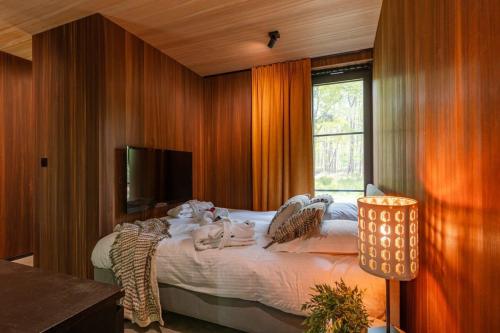 a bedroom with a large bed and a window at Cabin in the woods with hottub in Stekene