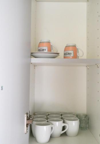 a shelf with cups and bowls on it at Stella’s Minimal Lodge in Tríkala
