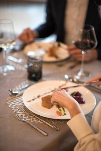 a person sitting at a table with a plate of food at Josef Mountain Resort in Avelengo