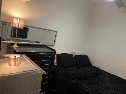 ein Schlafzimmer mit einem Bett und eine Kommode mit einem Spiegel in der Unterkunft Upper East Side 1 bedroom in New York