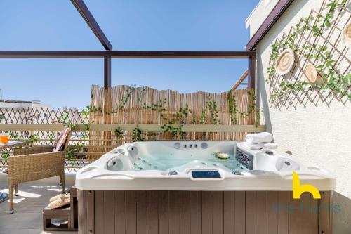 a jacuzzi tub sitting on a patio at Athenian Sky Retreat: Jacuzzi & Fresh Elegance! in Athens