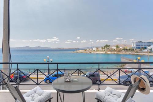 a balcony with a table and chairs and the ocean at Chic, Modern Seaside Oasis in Sunny Piraeus! in Piraeus