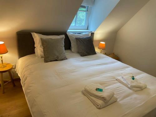a bedroom with a bed with two towels on it at Two guest-rooms in stylish villa - free bikes in Bruges