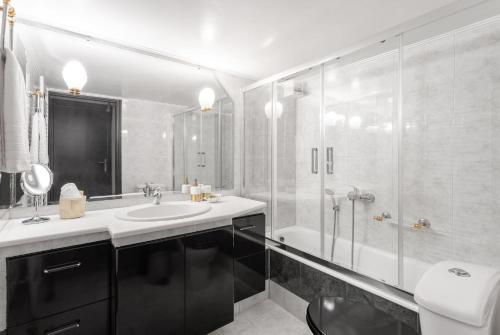 ein Bad mit einer Glasdusche und einem Waschbecken in der Unterkunft Fresh Detailed Stylish Apartment at Acropolis in Athen