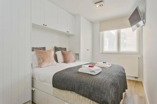 een slaapkamer met een bed met twee handdoeken erop bij Stunning new and modern apartment with large terrace and free parking in Knokke-Heist
