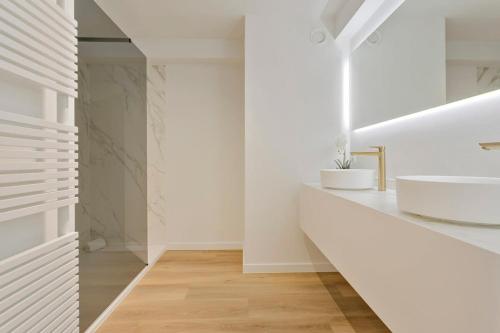 een witte badkamer met 2 wastafels en een spiegel bij Stunning new and modern apartment with large terrace and free parking in Knokke-Heist