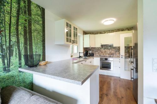 a kitchen with white cabinets and a window with trees at Alpenlodge Charivari - SommerBergBahn unlimited kostenlos in Oberstdorf