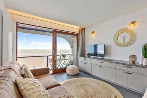 un salon avec un canapé et une vue sur l'océan dans l'établissement Huswell - Studio with great sea view on terrace, à Knokke-Heist