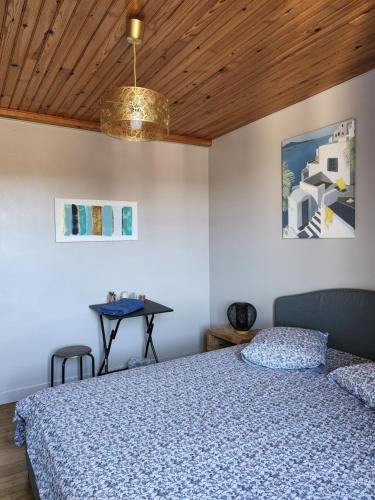 Schlafzimmer mit einem Bett und einem Tisch in der Unterkunft la chambre d'Axelle in La Bachellerie