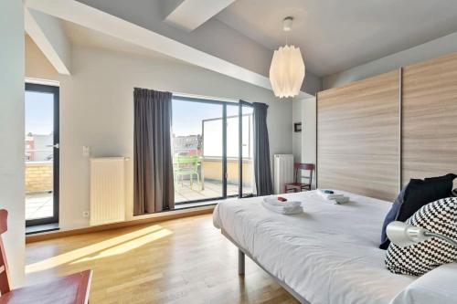 um quarto com uma cama e uma grande janela em Apartment with spacious terrace and stunning view em Oostende