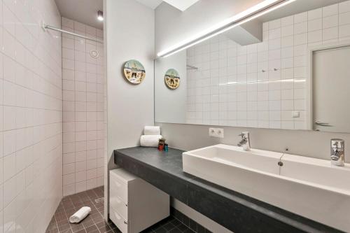 uma casa de banho com um lavatório e um espelho em Apartment with spacious terrace and stunning view em Oostende