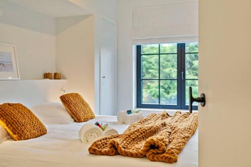 um quarto com uma cama branca com almofadas de leopardo em Renovated apartment nearby the beach in Knokke-Heist em Knokke-Heist