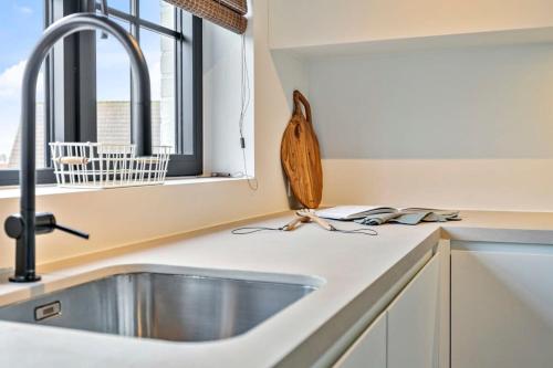 um balcão de cozinha com um lavatório e uma janela em Renovated apartment nearby the beach in Knokke-Heist em Knokke-Heist