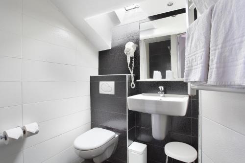 a black and white bathroom with a toilet and a sink at Garden Saint Martin in Paris