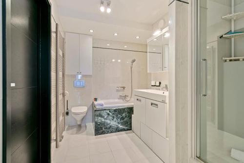 een witte badkamer met een toilet en een wastafel bij Modern penthouse with stunning sea-view, sauna and 2 large terraces! in Knokke-Heist