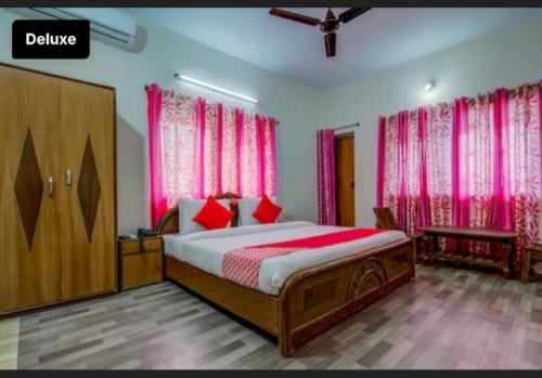 a bedroom with a large bed with pink curtains at The Lemon Chile in Rānchī