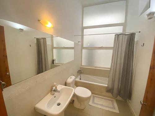 uma casa de banho com um lavatório, um WC e um espelho. em Gizimin, Stylish, modern, central apartment em Tal-Għoqod
