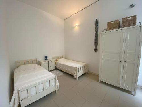 a white room with two beds and a cabinet at Gizimin, Stylish, modern, central apartment, 37, Triq L-Adrijatiku, San Gwann in Tal-Għoqod