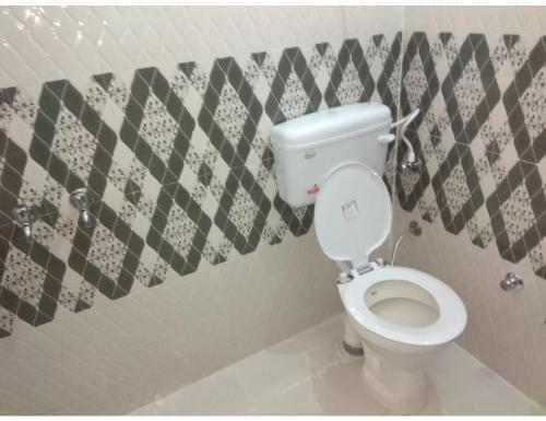 a bathroom with a white toilet in a room at Hotel Devansh Uttarkashi in Uttarkāshi