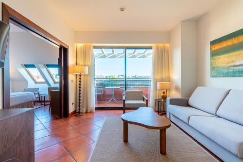 a living room with a couch and a table at Puerto Antilla Grand Hotel in Islantilla