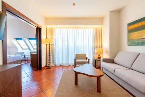 a living room with a couch and a table at Puerto Antilla Grand Hotel in Islantilla