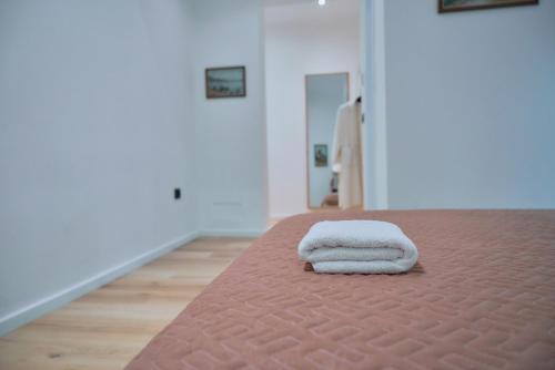 a stack of towels sitting on top of a bed at Kalpazo Inn Tirana in Tirana