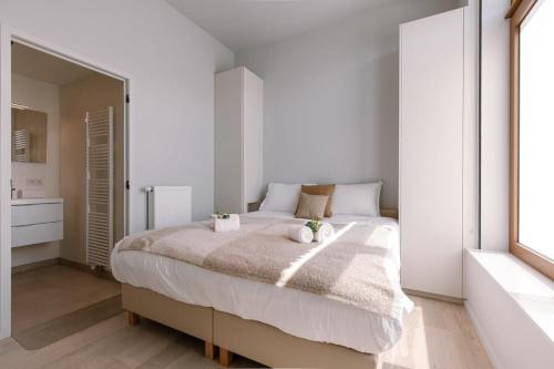 een slaapkamer met een groot bed met twee knuffels erop bij Luxurious flat "de zilte zeezoen" close to the sea in Oostende