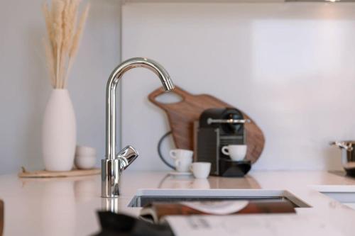 a kitchen counter with a sink and a coffee maker at Luxurious flat "de zilte zeezoen" close to the sea in Ostend