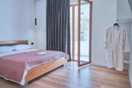 a bedroom with a bed and a sliding glass door at Kalpazo Inn Tirana in Tirana