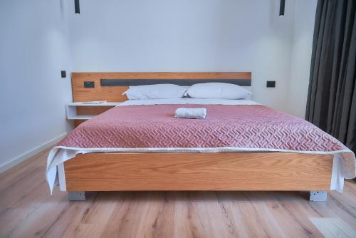 a bedroom with a large bed with a wooden headboard at Kalpazo Inn Tirana in Tirana