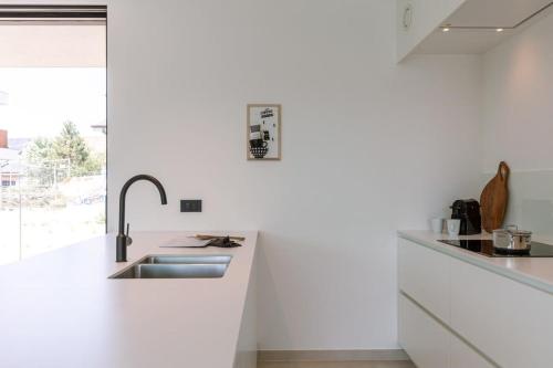 New, luxurious and modern apartment with private parking في كوكسيجدي: مطبخ أبيض مع حوض ونافذة