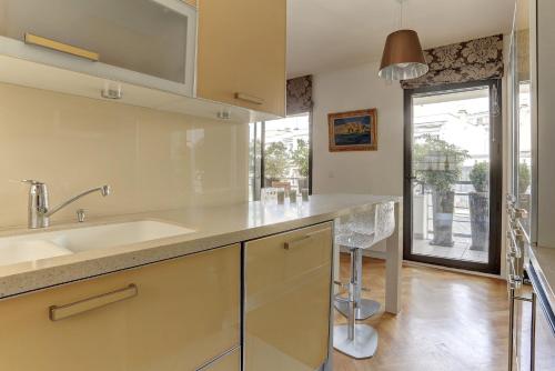 une cuisine avec un évier et une grande fenêtre dans l'établissement Le Vernet - Boulogne, à Boulogne-Billancourt