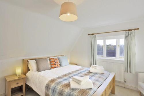 a bedroom with a bed and a window at Dovedale in Reydon